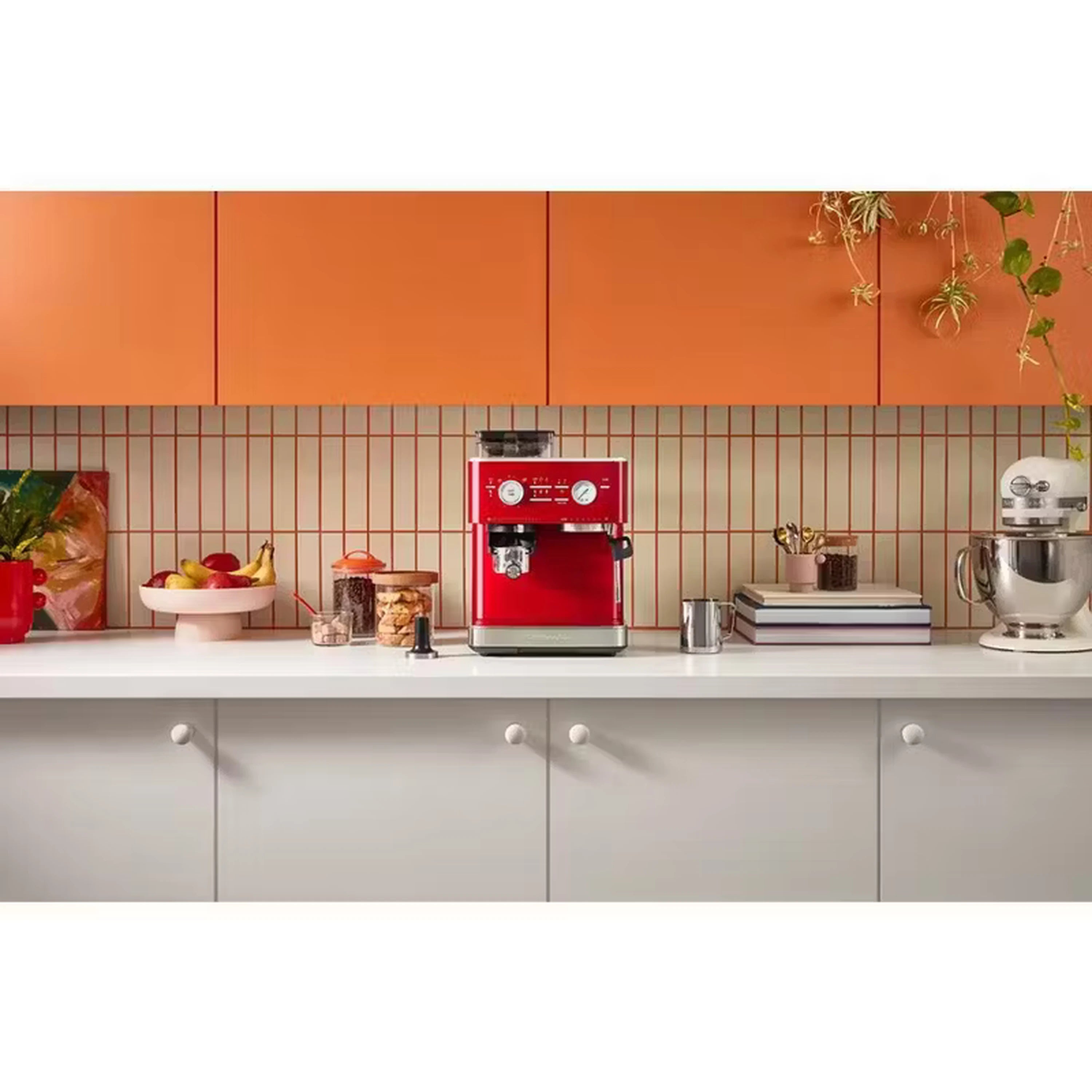 Red fully automatic espresso machine with accessories on kitchen countertop