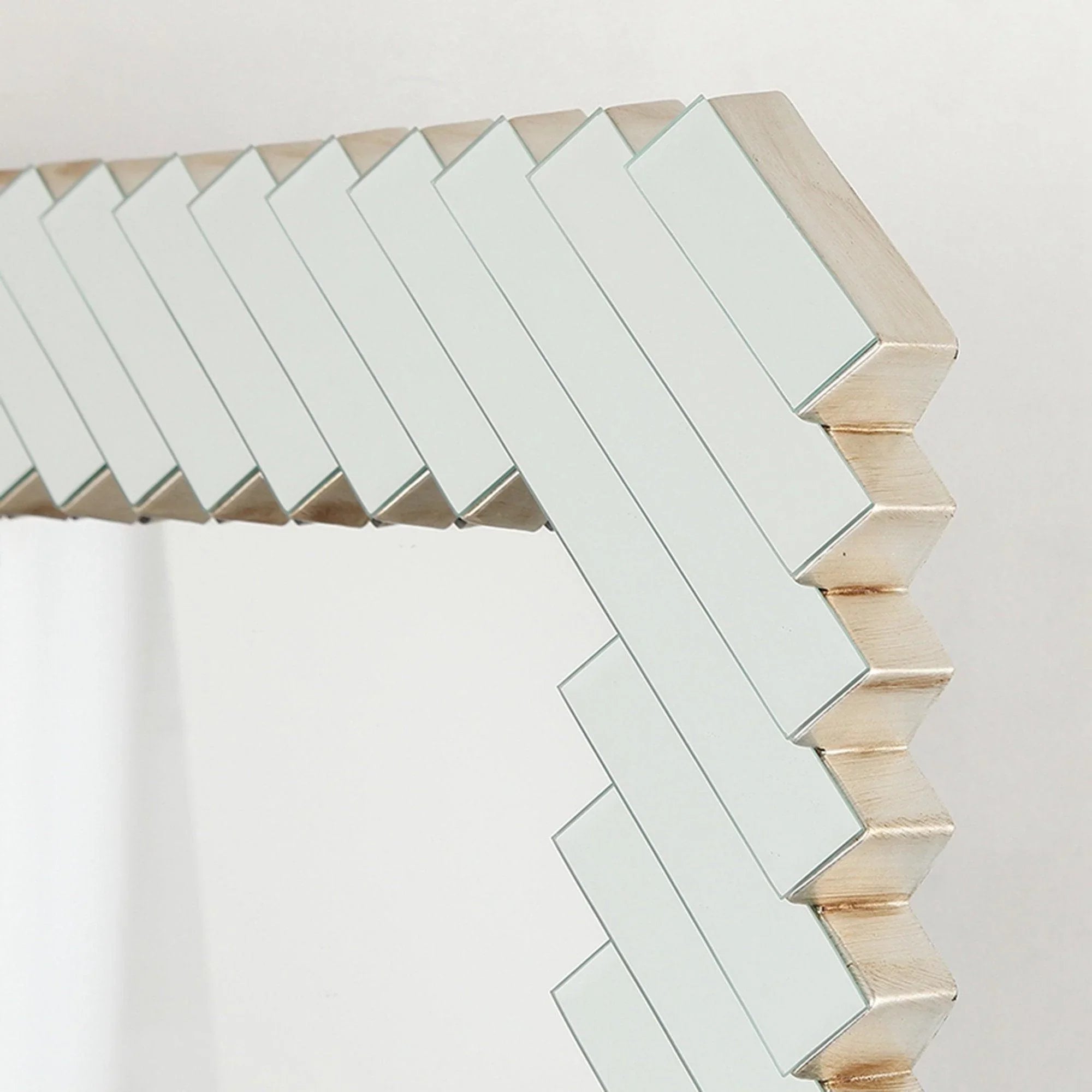 Angled close-up of silver and white slat border on a rectangular framed mirror