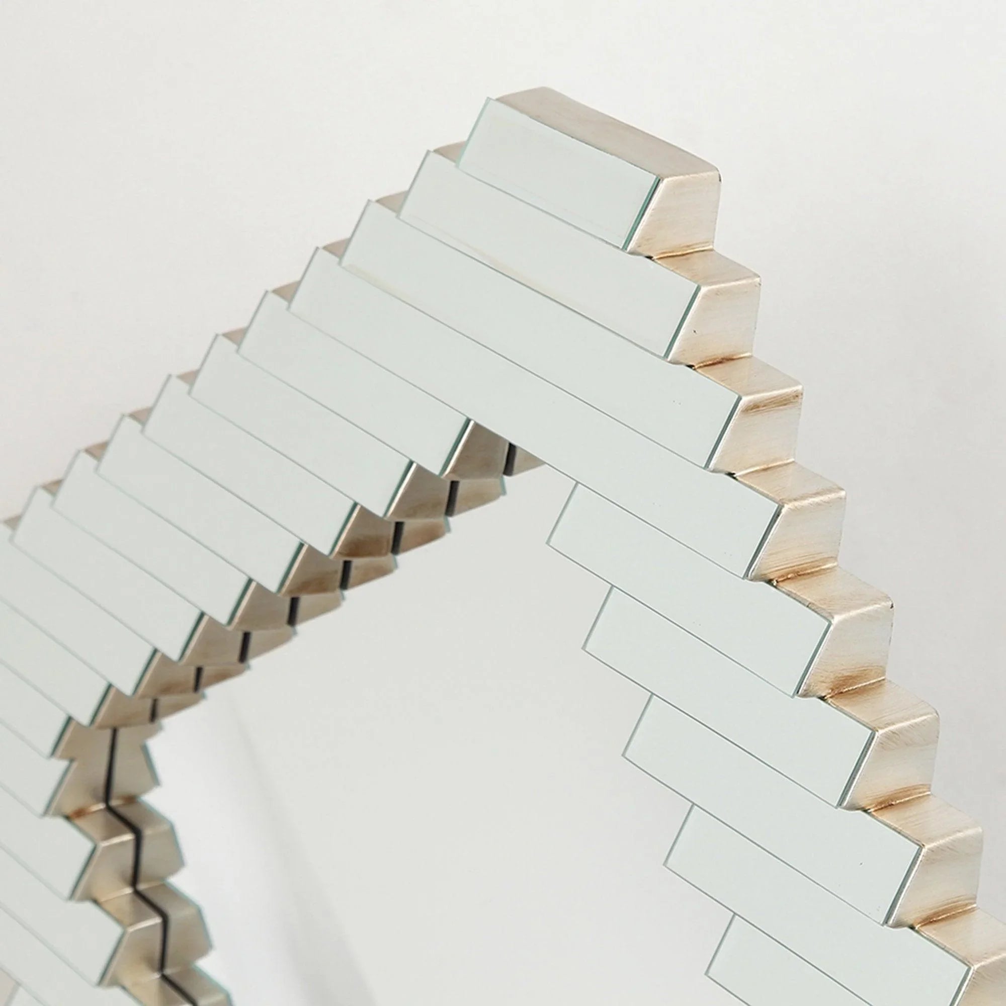 Curved corner detail of a rectangular decorative mirror with silver slat frame