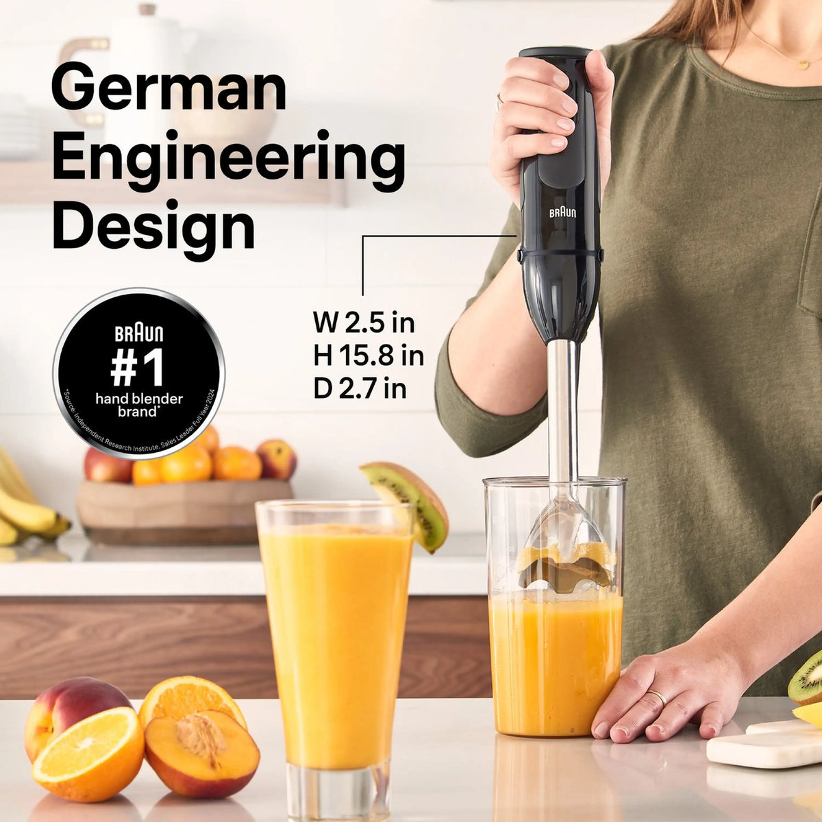 Braun black hand blender held over a clear cup with orange smoothie