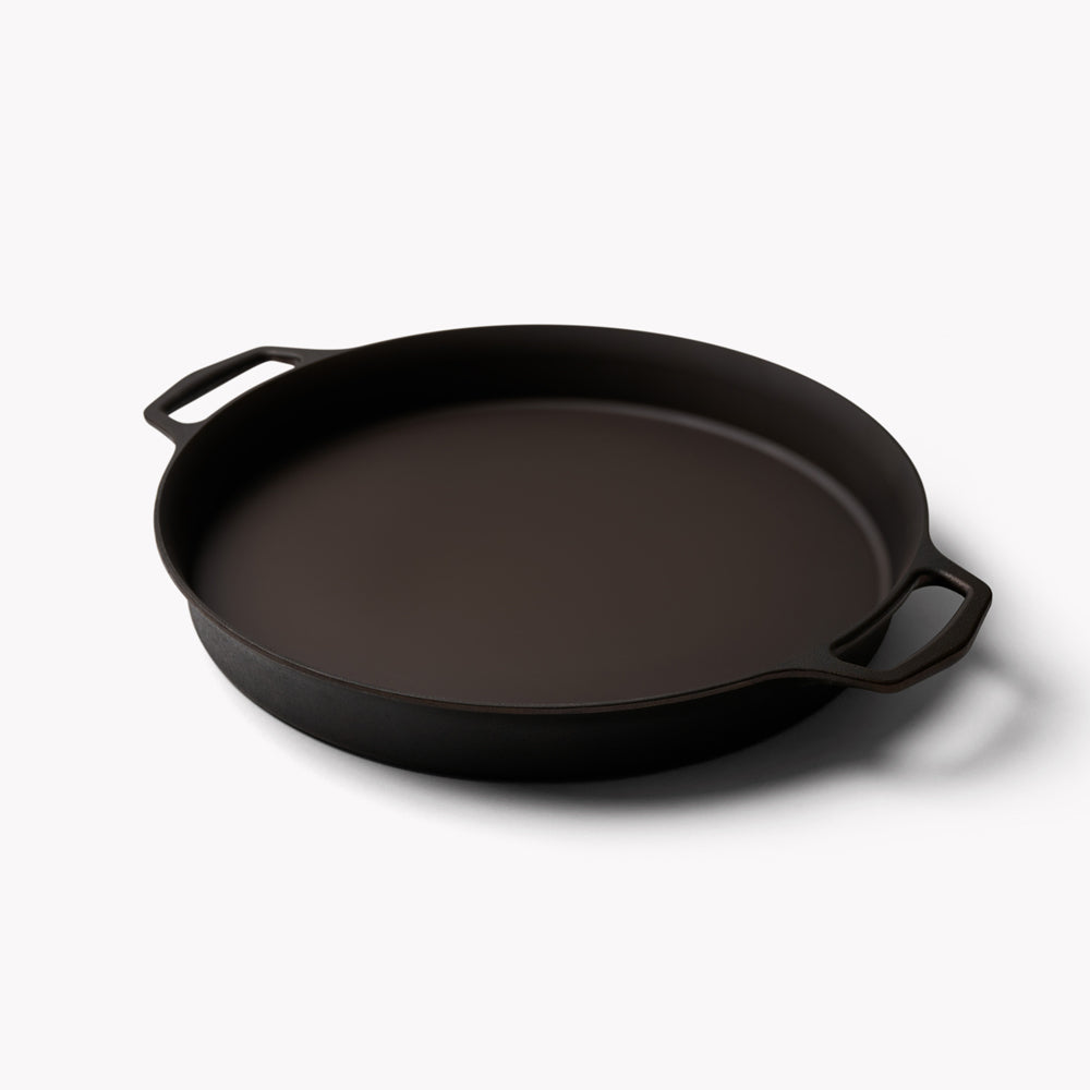 Black double-handled cast iron skillet with smooth interior and side handles