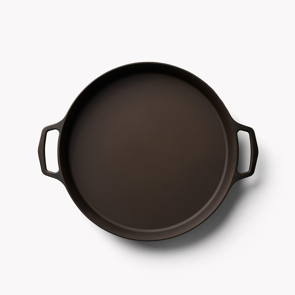 Black double-handled cast iron skillet, round pan with two side loop handles