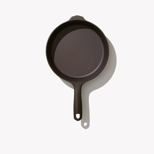 Black cast iron skillet with wide rim and short loop handle