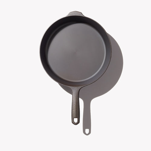Black cast iron frying pan with smooth cooking surface and loop handle