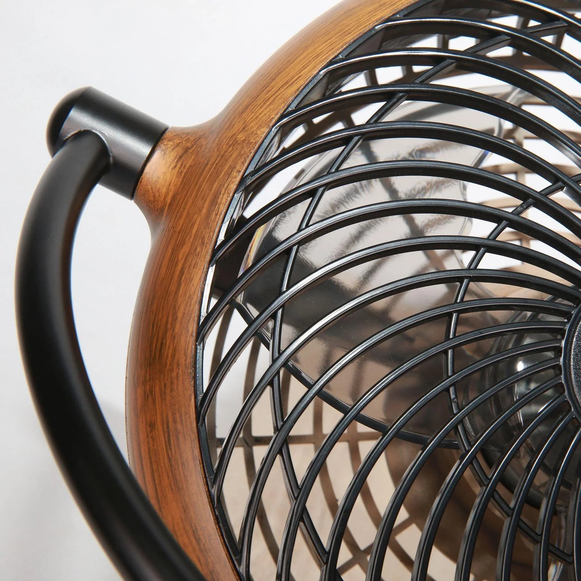 Close-up of brown wood-look fan housing with black protective metal grill
