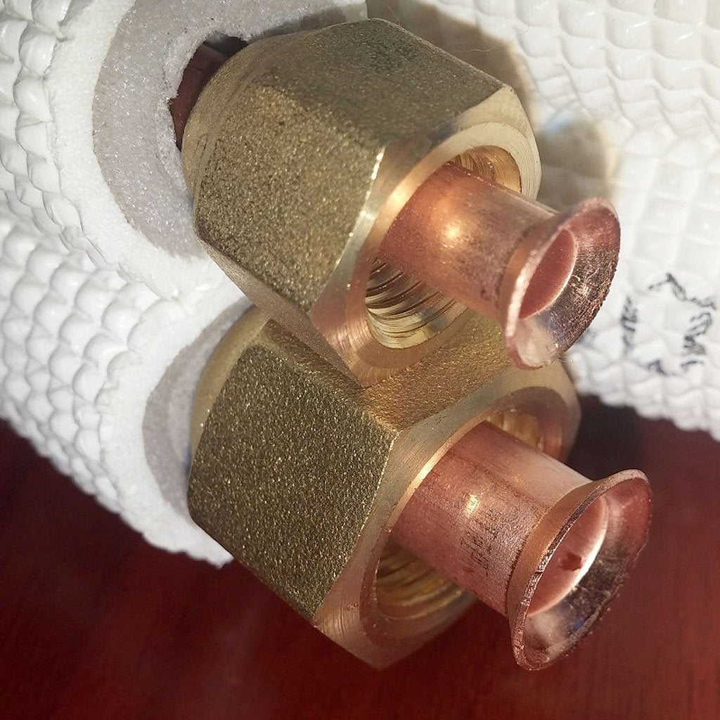 Mini split copper piping flare fittings with brass adapters on insulated foam