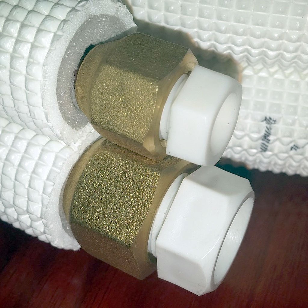 Mini split copper line set with paired shutoff fittings, white caps, and foam insulation