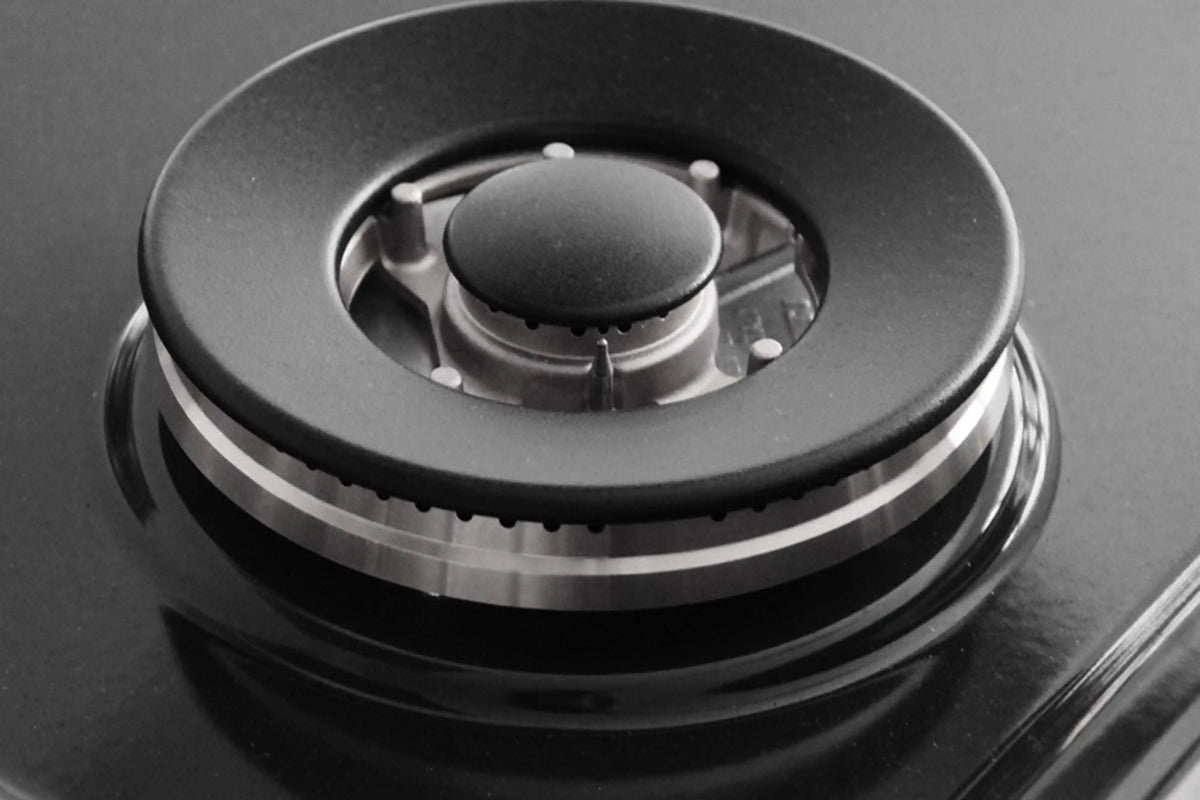 Single gas burner cap and grate on a dark cooktop surface