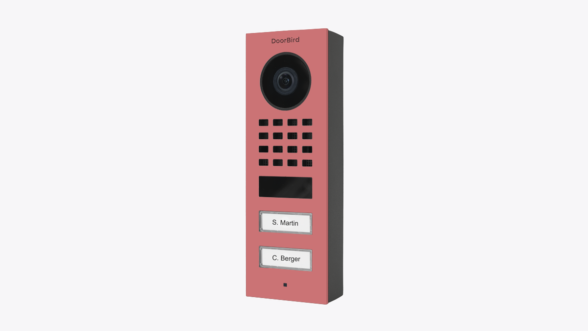 DoorBird surface-mount video door station, antique pink front with camera, speaker grille, buttons