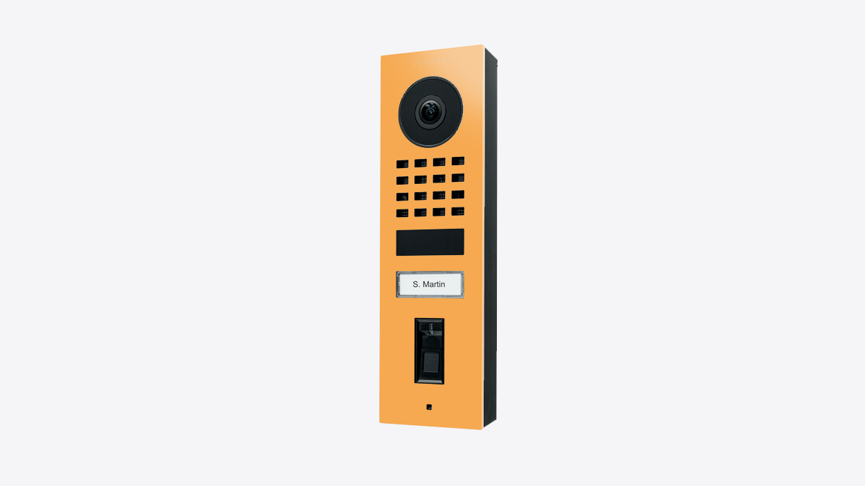 Saffron yellow surface-mount video door station with camera and speaker grille