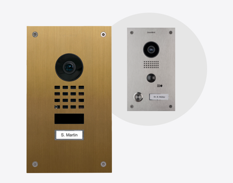 DoorBird video door station in gold with camera, speaker grille, and nameplate