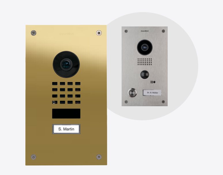 DoorBird video door station in brass with camera lens, speaker grille, and door buttons