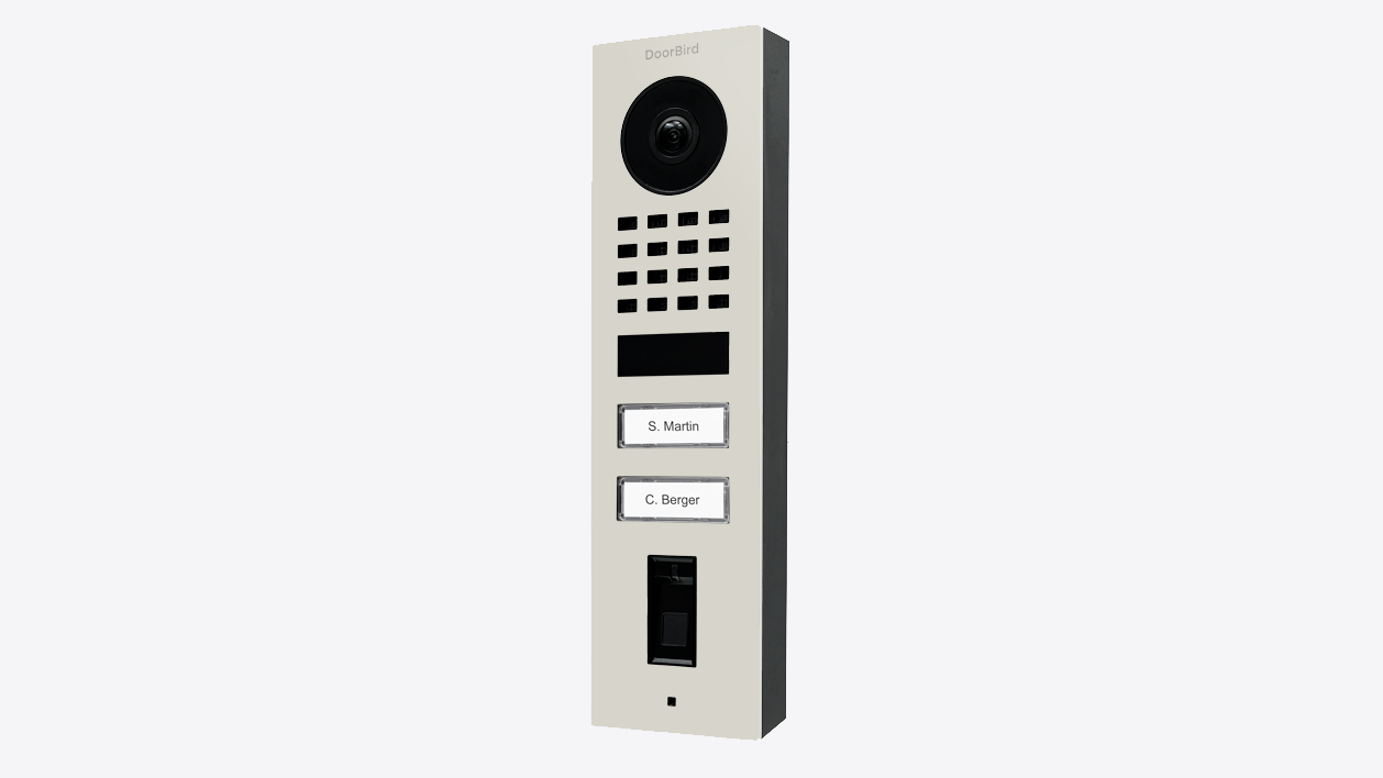 Grey DoorBird surface-mount video door station, front view with camera and keypad