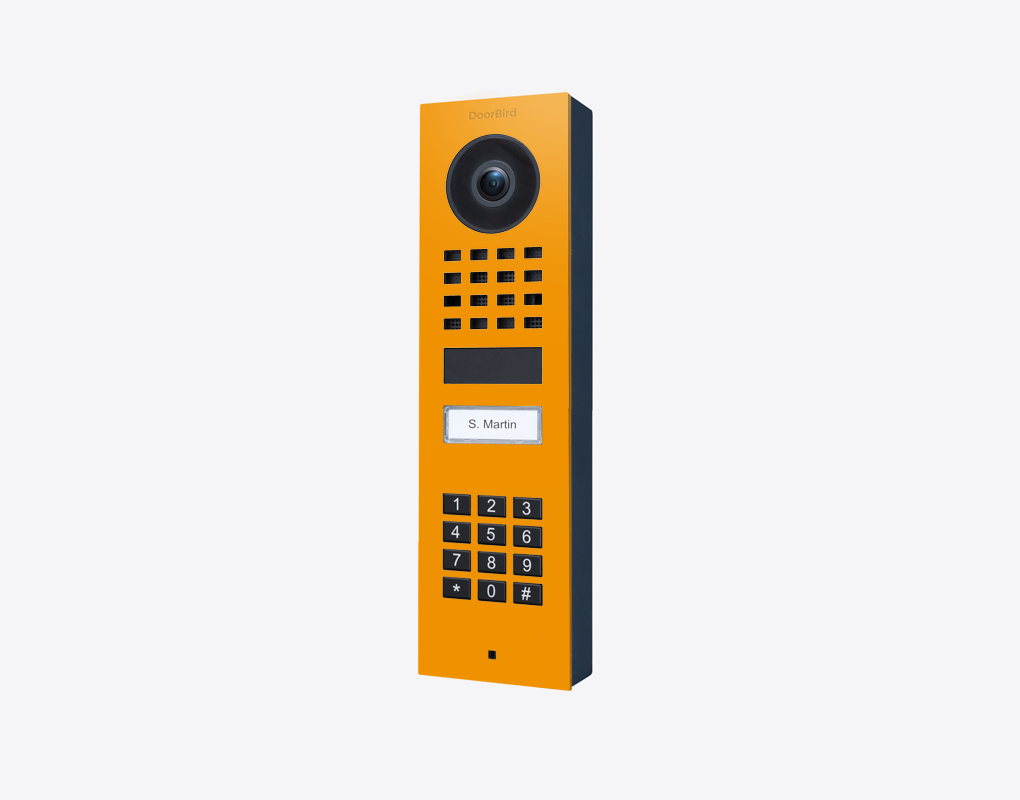 DoorBird D1101KV surface-mount IP video door station in sun yellow, front with camera and keypad