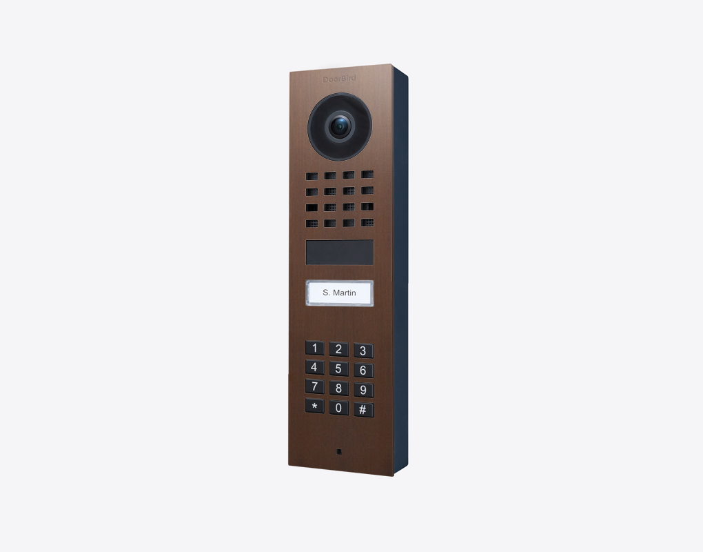 DoorBird surface-mount video door station in architectural bronze, camera, keypad, call button