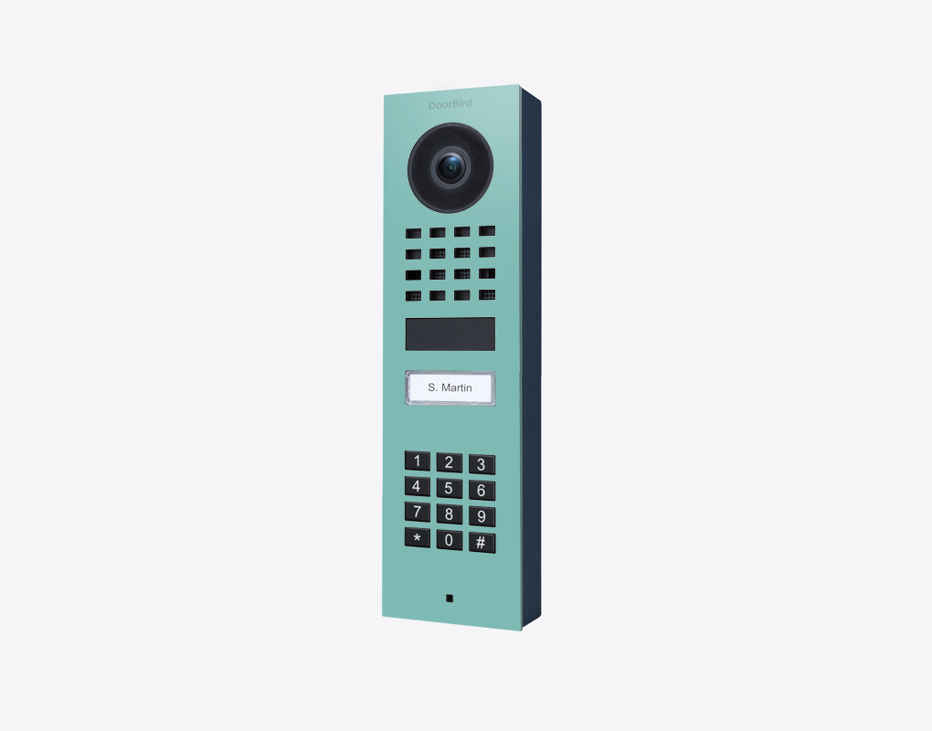 DoorBird surface-mount video door station in light green with camera and numeric keypad