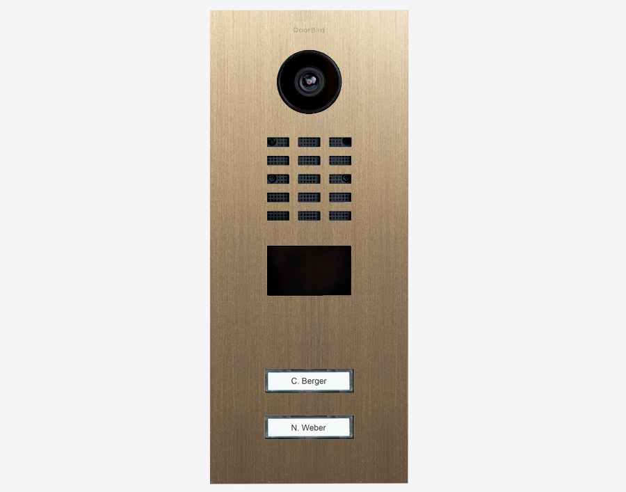 Burnished brass DoorBird video door station with camera, speaker grille, and two labels