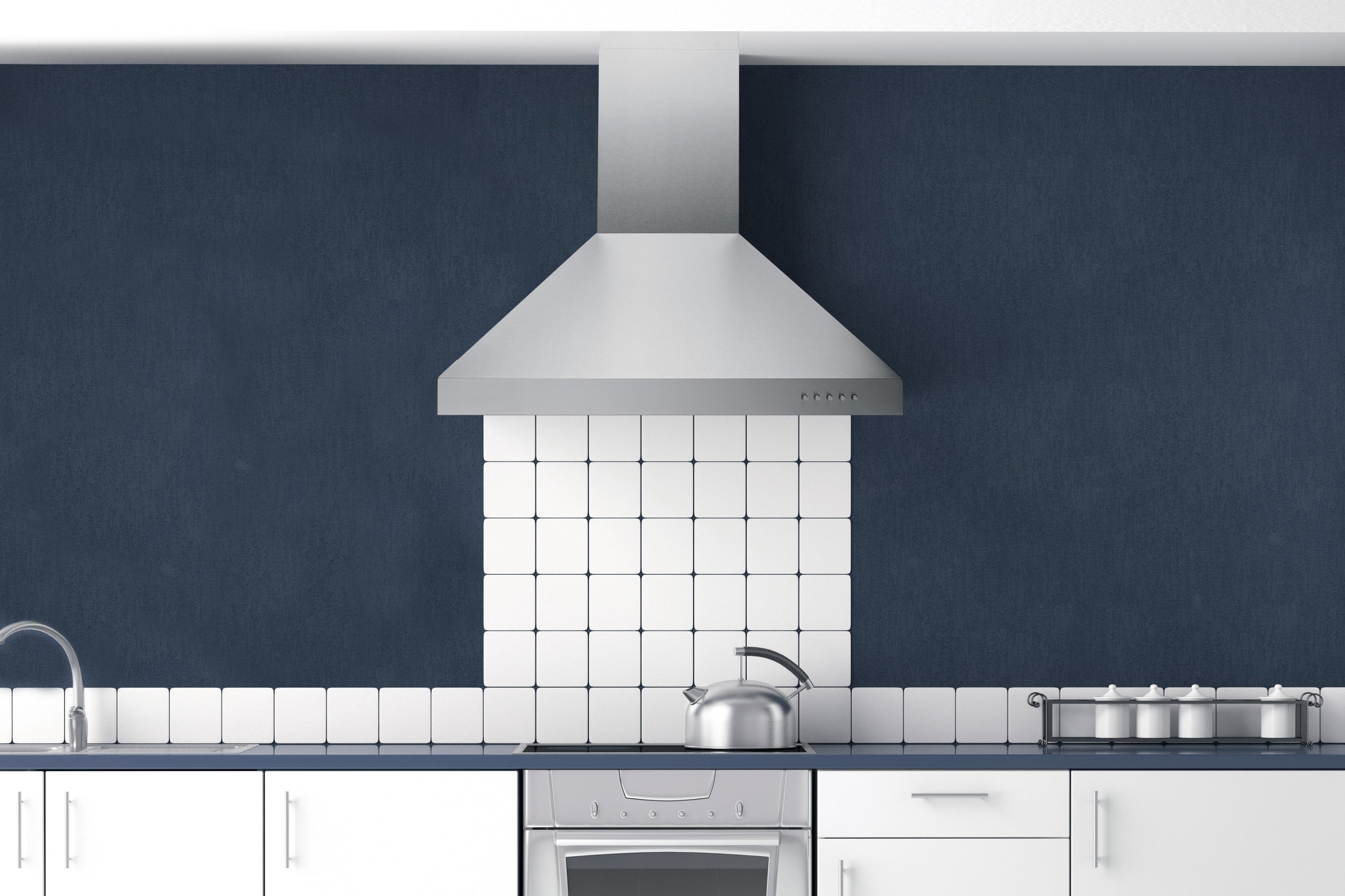 Stainless steel range hood over a stove in a kitchen, with chimney and vent