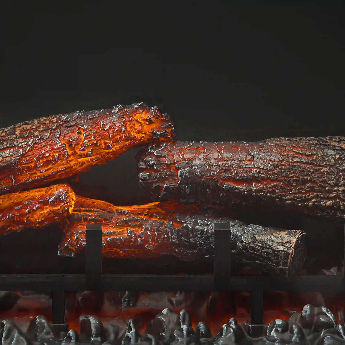 Electric fireplace logs with bright orange embers and flame glow in dark firebox