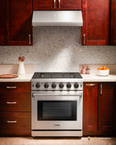 Stainless steel gas range with six burners and closed oven door in kitchen setting