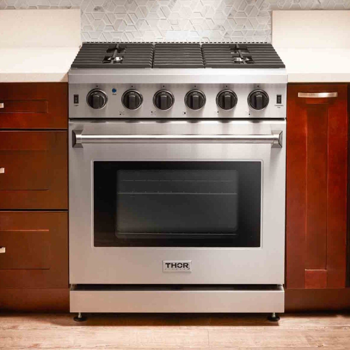 Stainless steel gas range with six burners, control knobs, and closed oven door