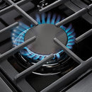 Stainless steel gas cooktop burner with blue flame and cast-iron grates