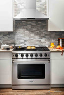 Stainless steel gas range in kitchen setting with oven door and top burners