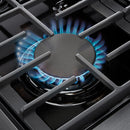 Gas burner grate with blue flame on stainless steel double oven range cooktop