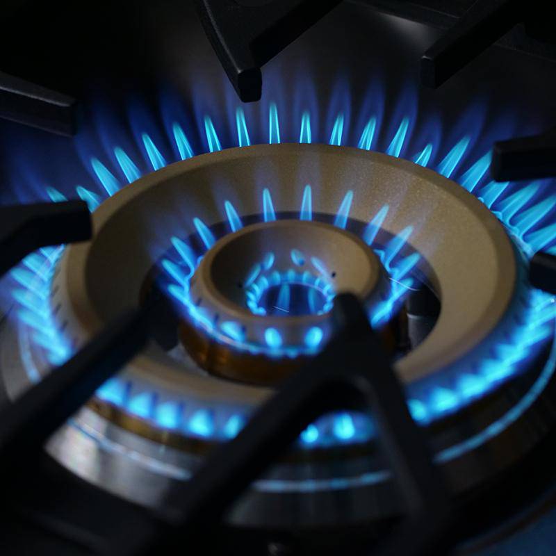 Blue gas flame tri-ring burner on stainless gas cooktop
