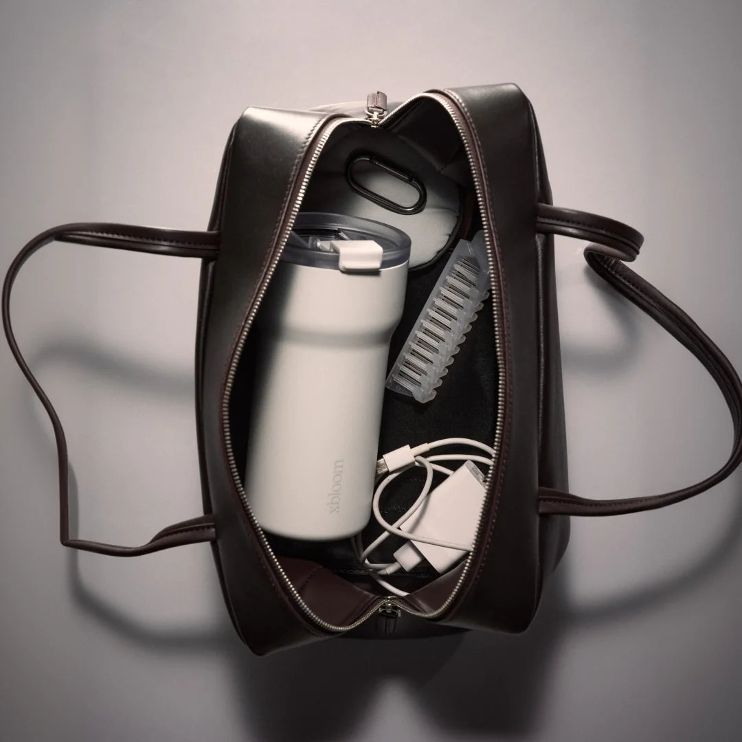 Passenger tumbler inside black travel sleeve with zipper and carry strap