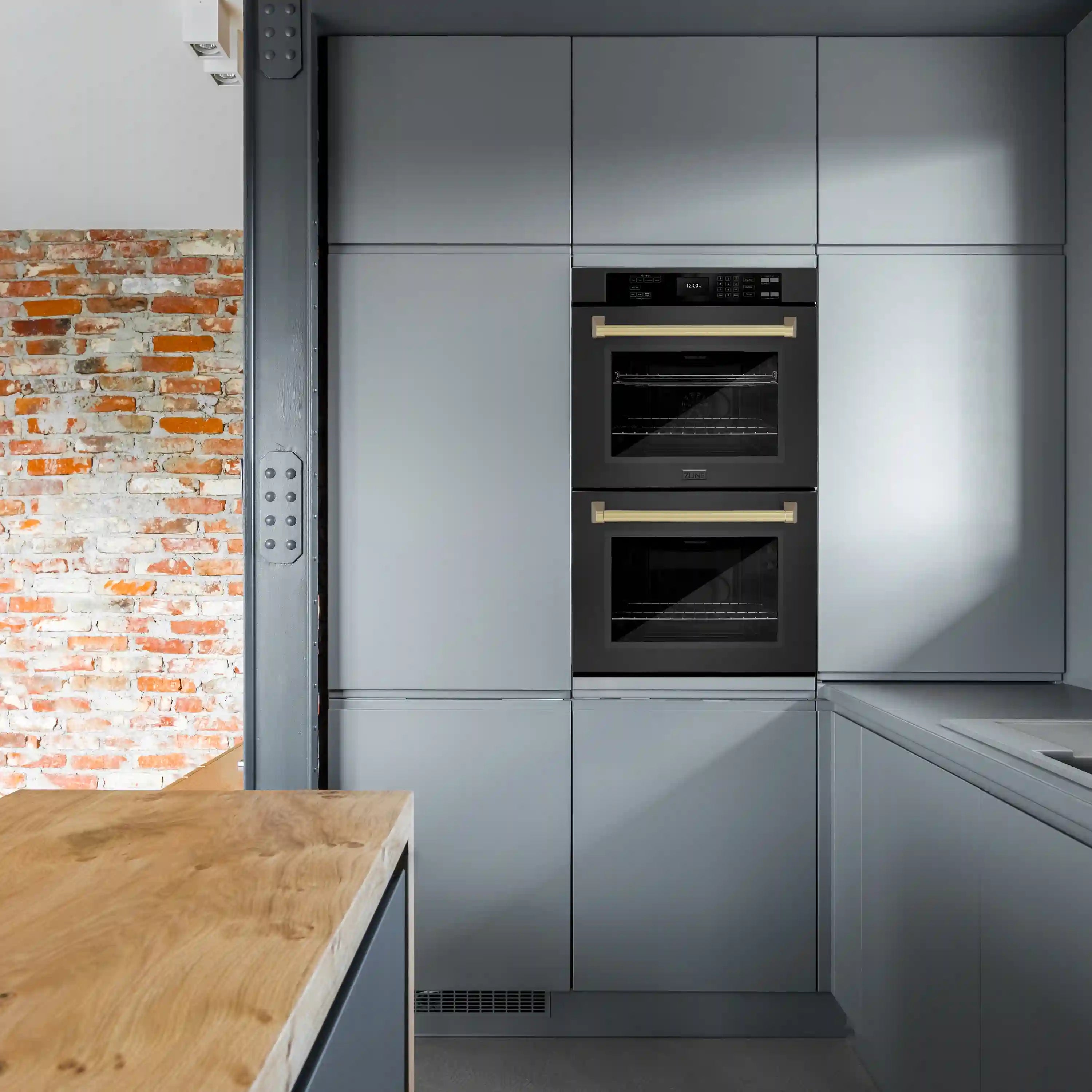 Built-in black stainless steel double wall oven with champagne bronze handles in cabinetry