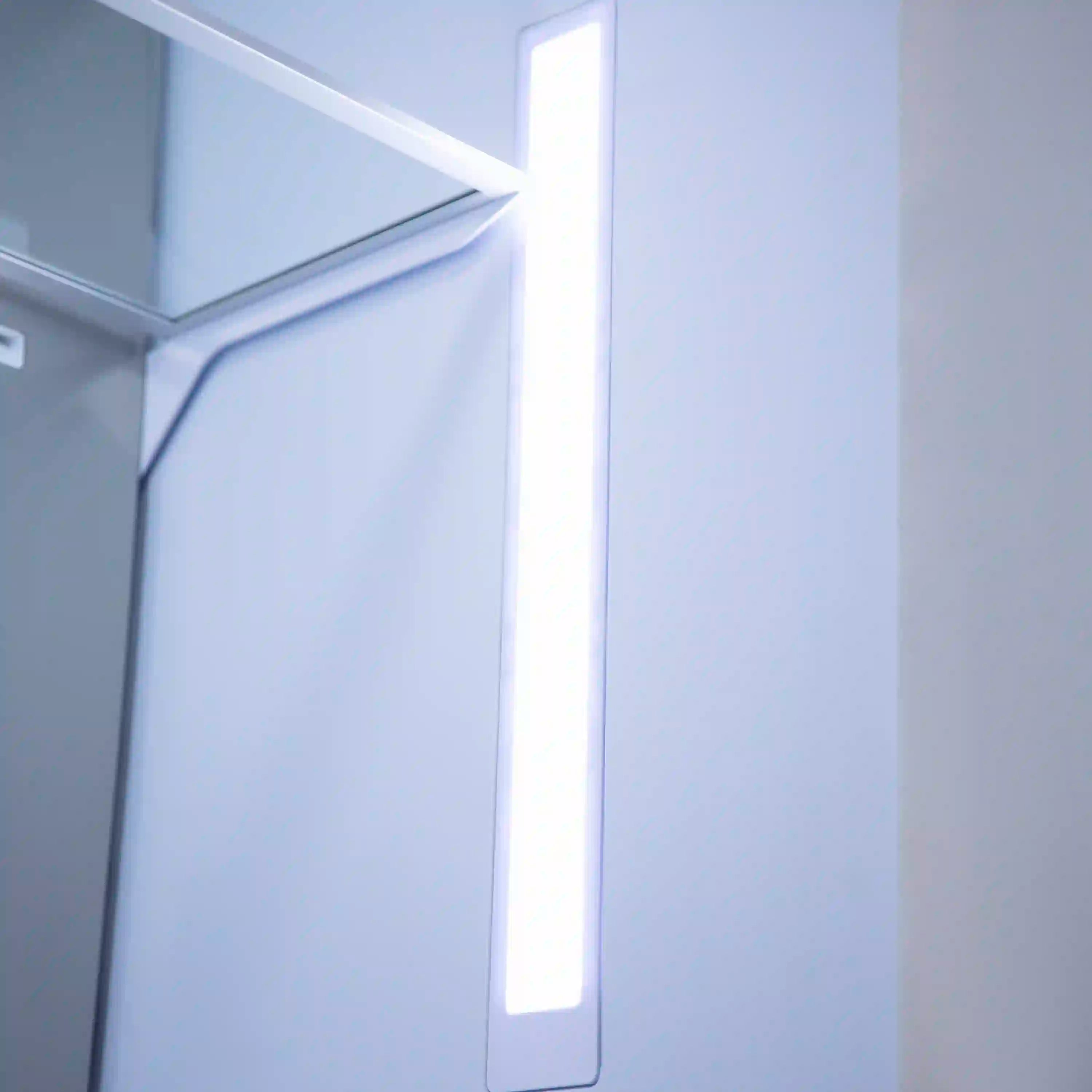 Stainless steel refrigerator door with a glowing internal dispenser light strip