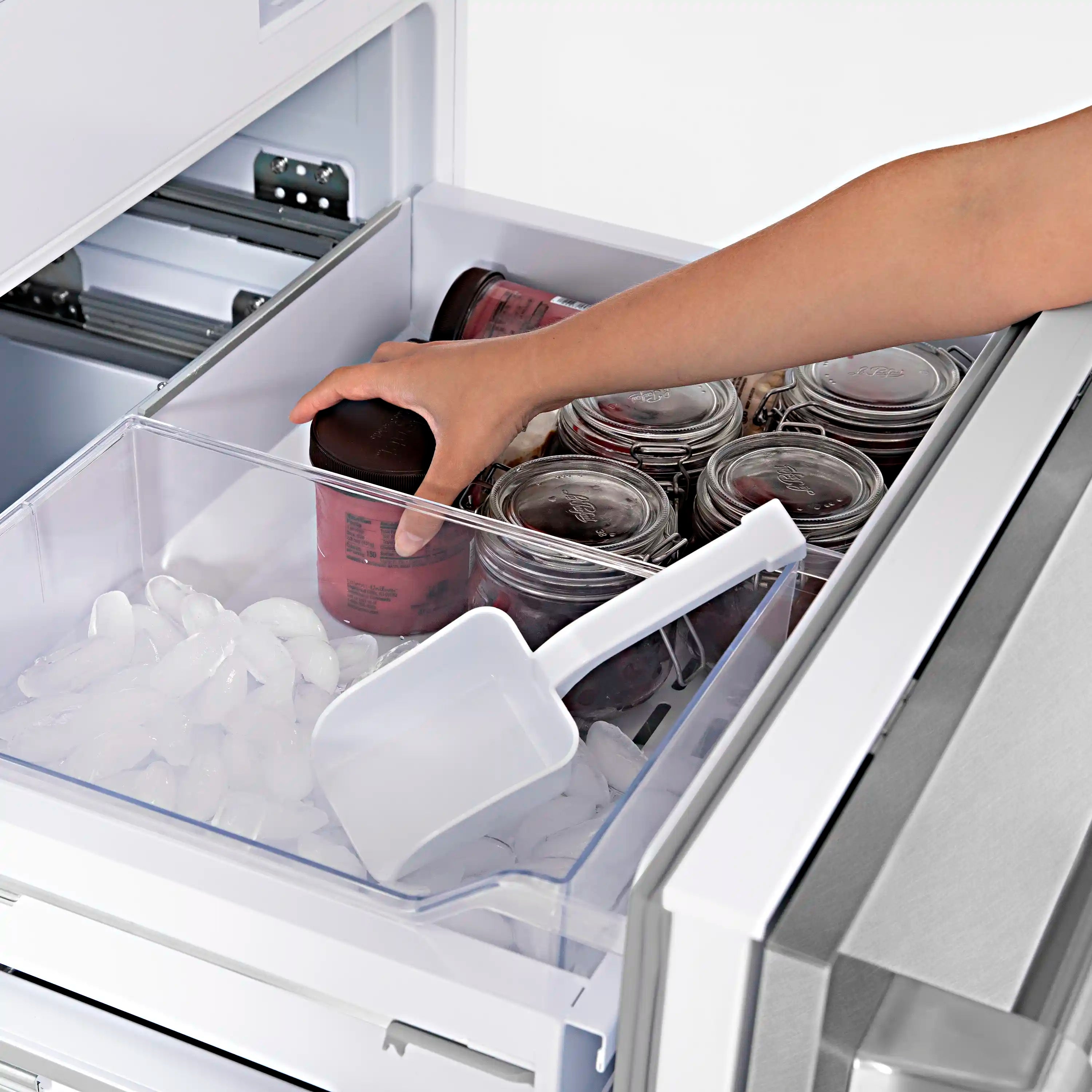 Built-in bottom freezer drawer open with ice and food bins