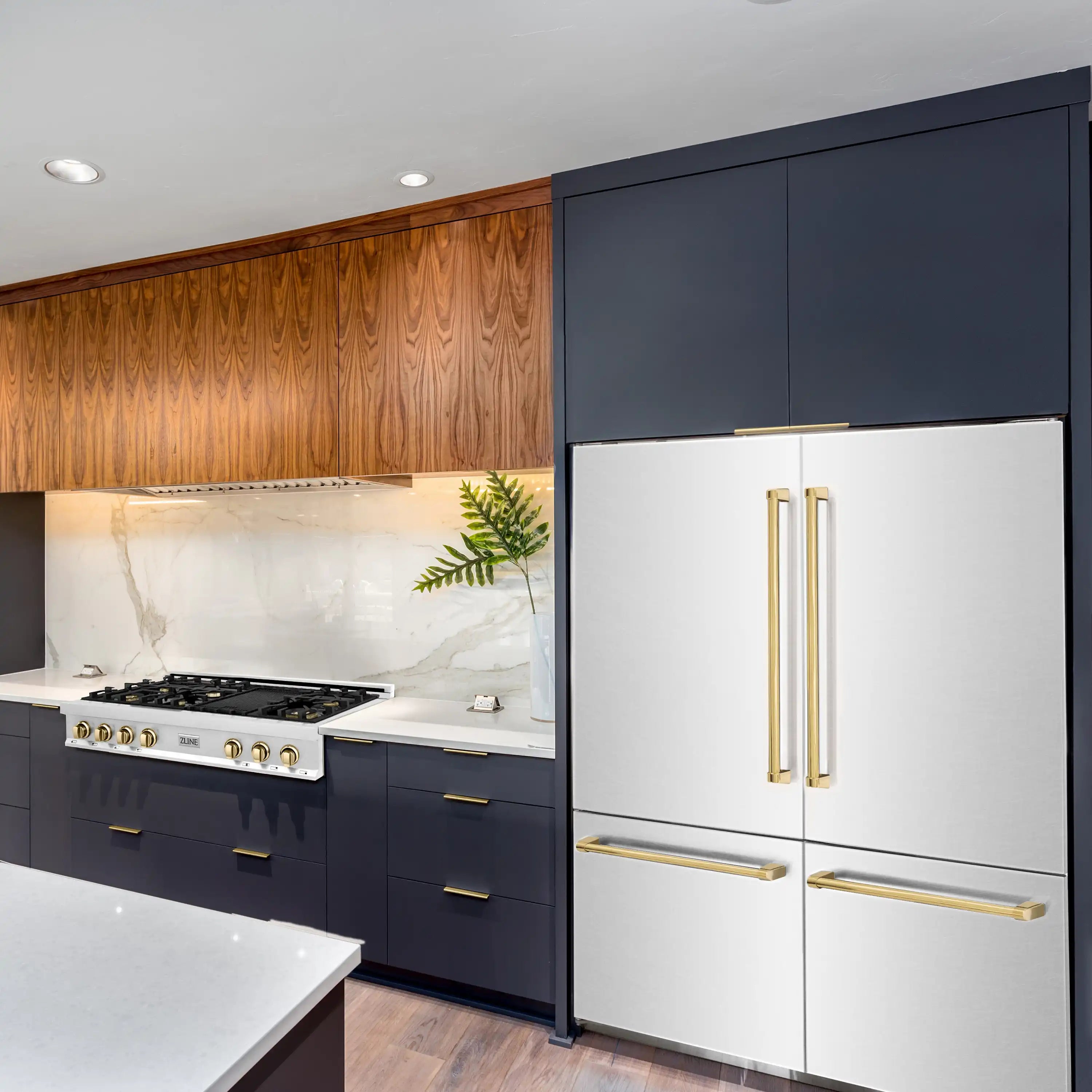 Built-in stainless refrigerator with gold handle accents in a kitchen