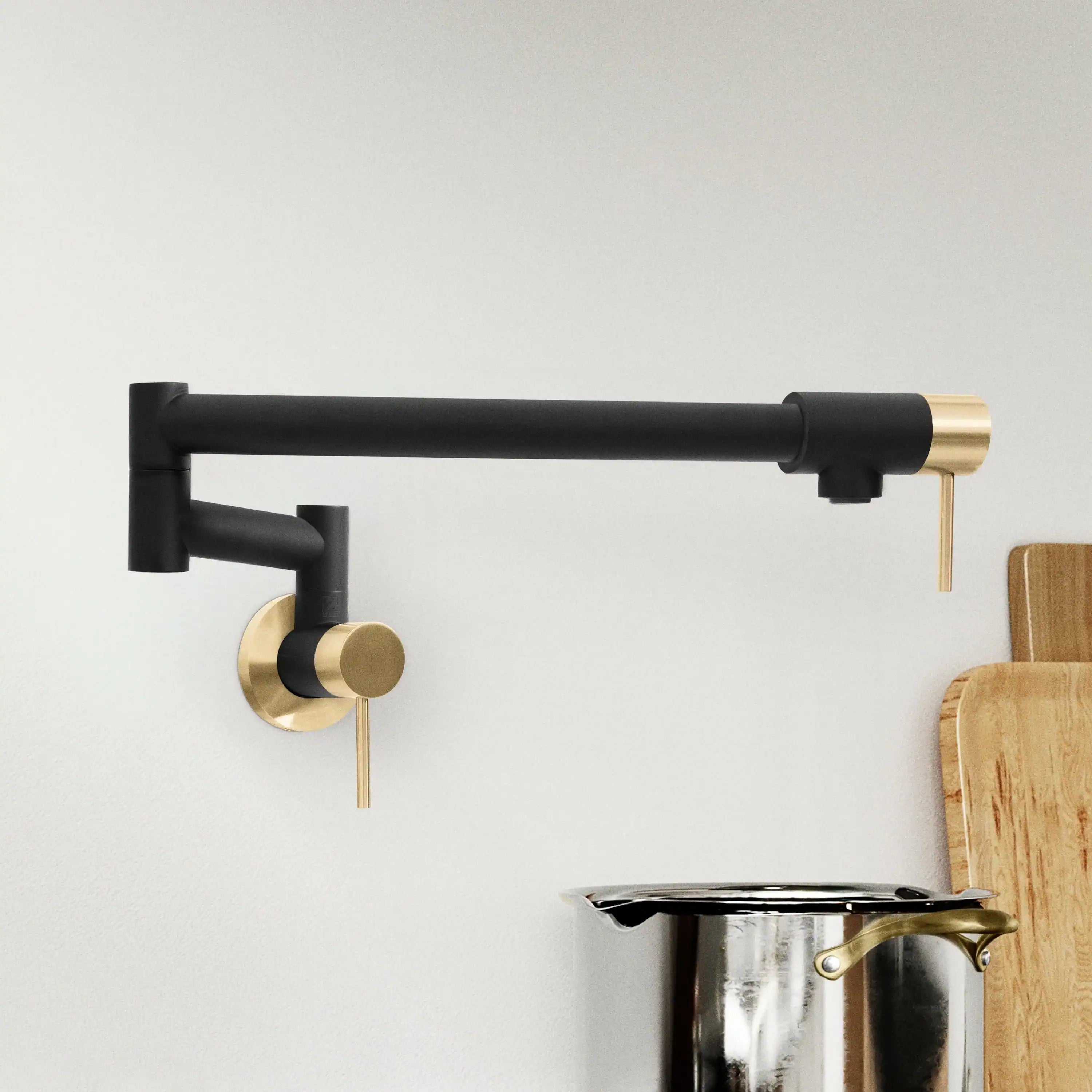 Matte black and champagne bronze pot filler faucet with swing spout and wall mount.
