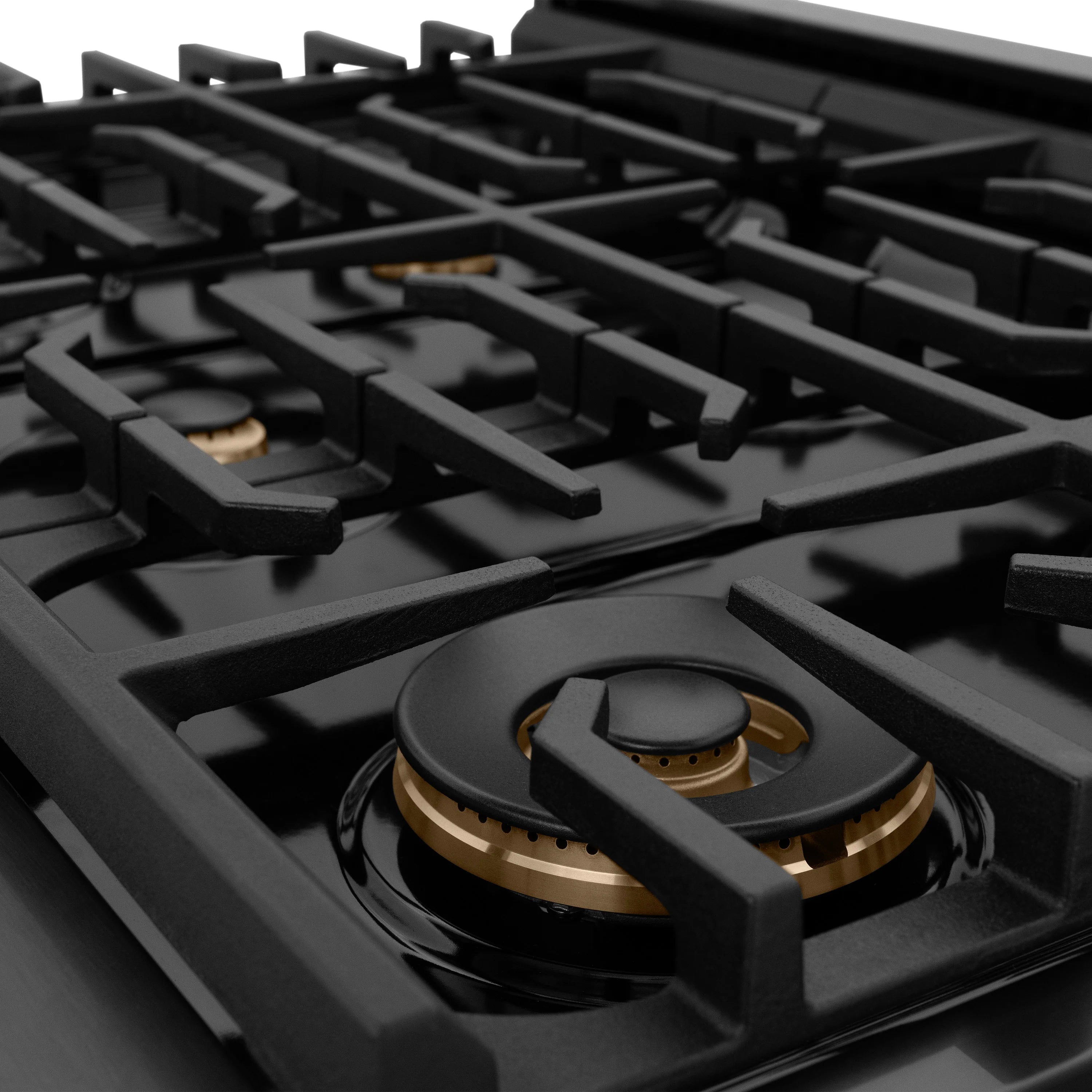 Black gas range cooktop with grates and visible champagne bronze burner ring