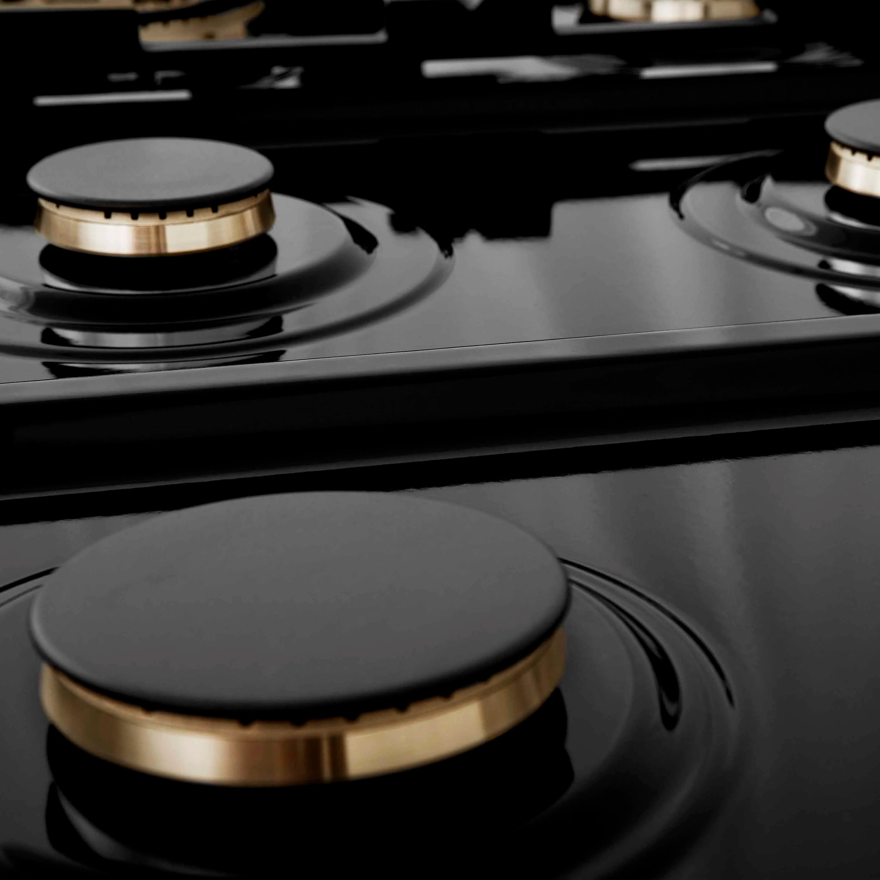 Close-up of black burner cap with champagne bronze ring on gas rangetop