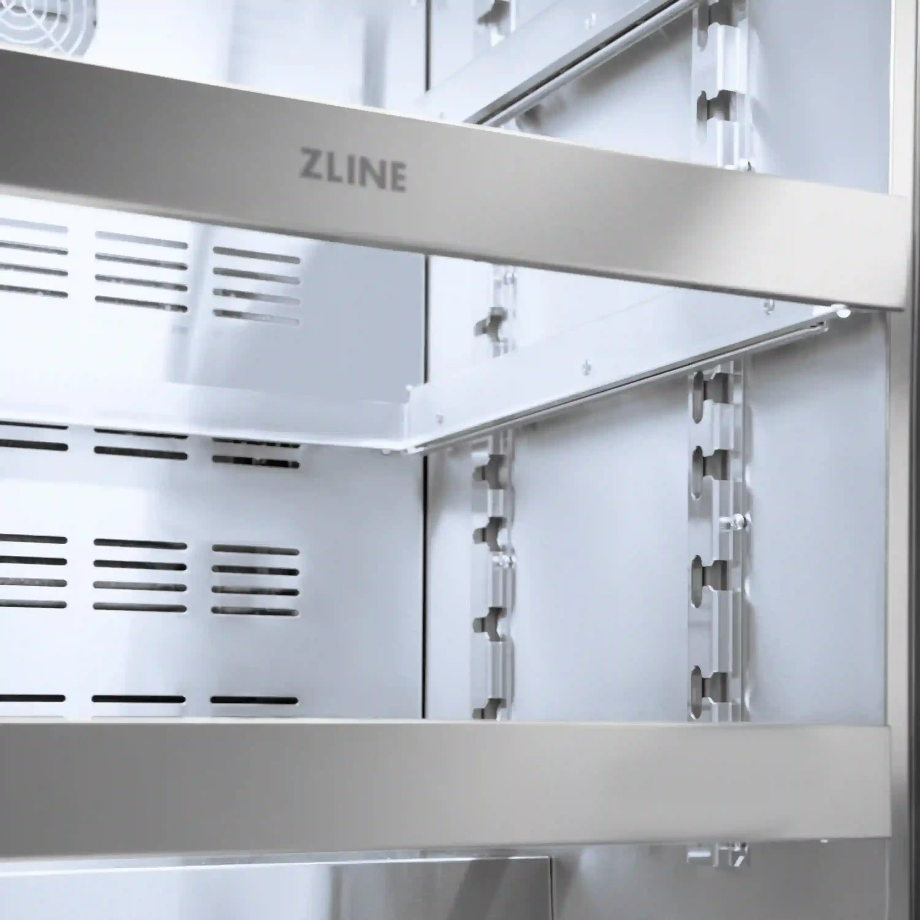 Stainless beverage fridge interior with ZLINE logo under-counter shelf rails and vents