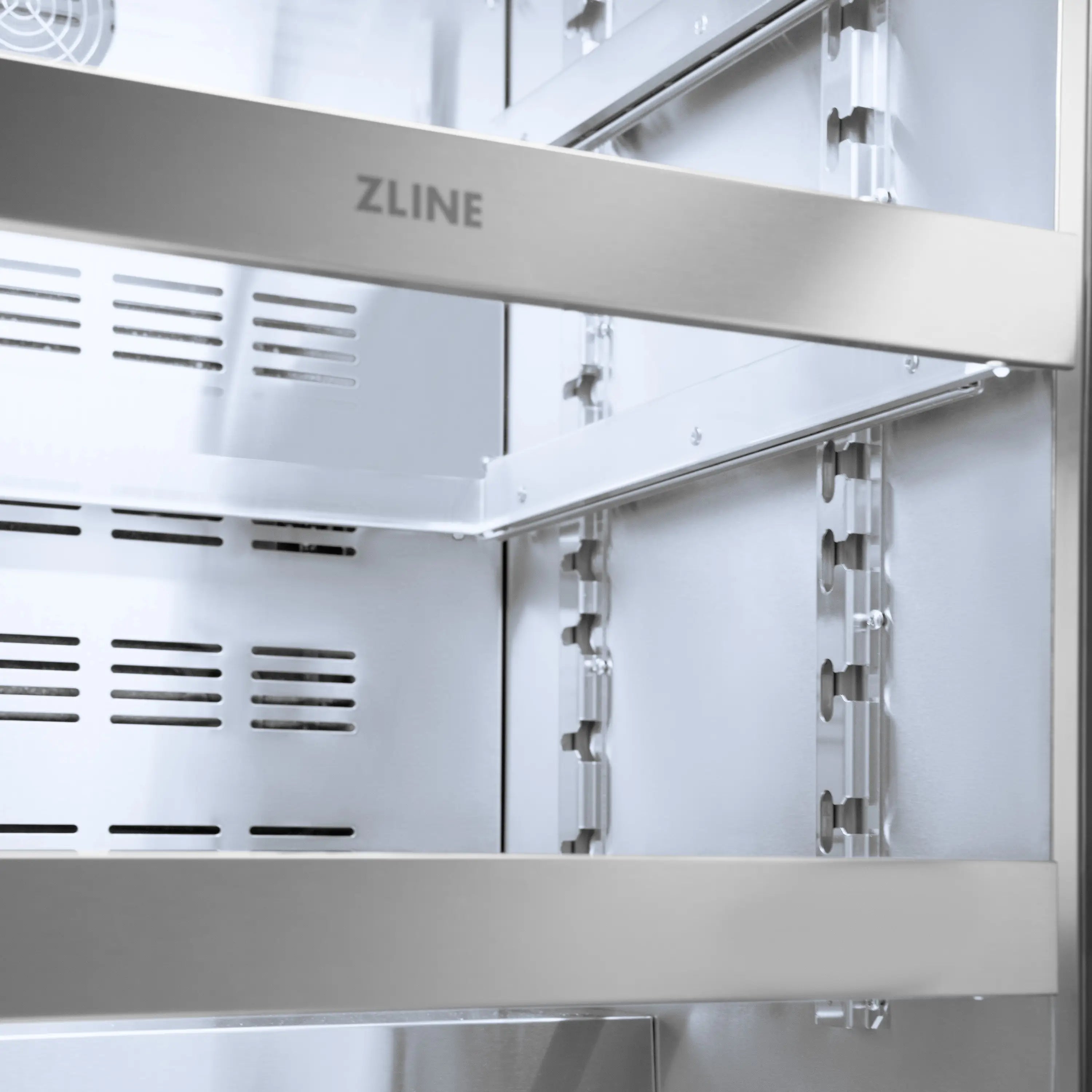 Open beverage fridge interior showing side cooling vents and adjustable shelf rails