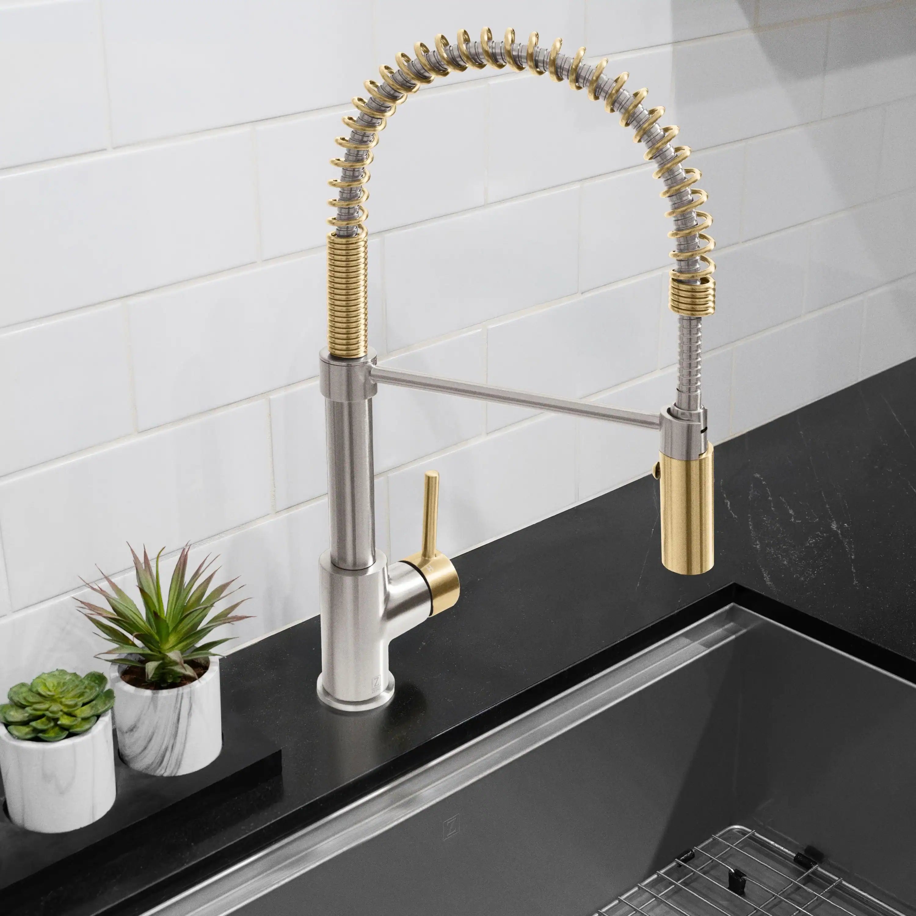 Pull-down kitchen faucet in brushed nickel with champagne bronze side handle on sink