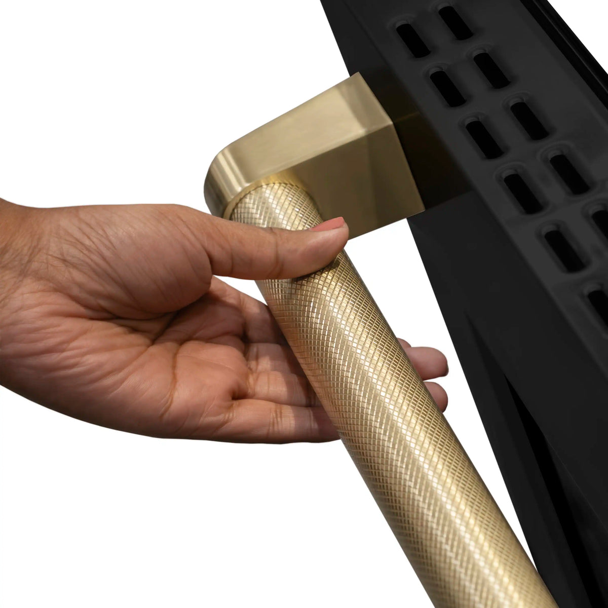 Hand fitting a champagne Helix-style cooktop knob onto the range