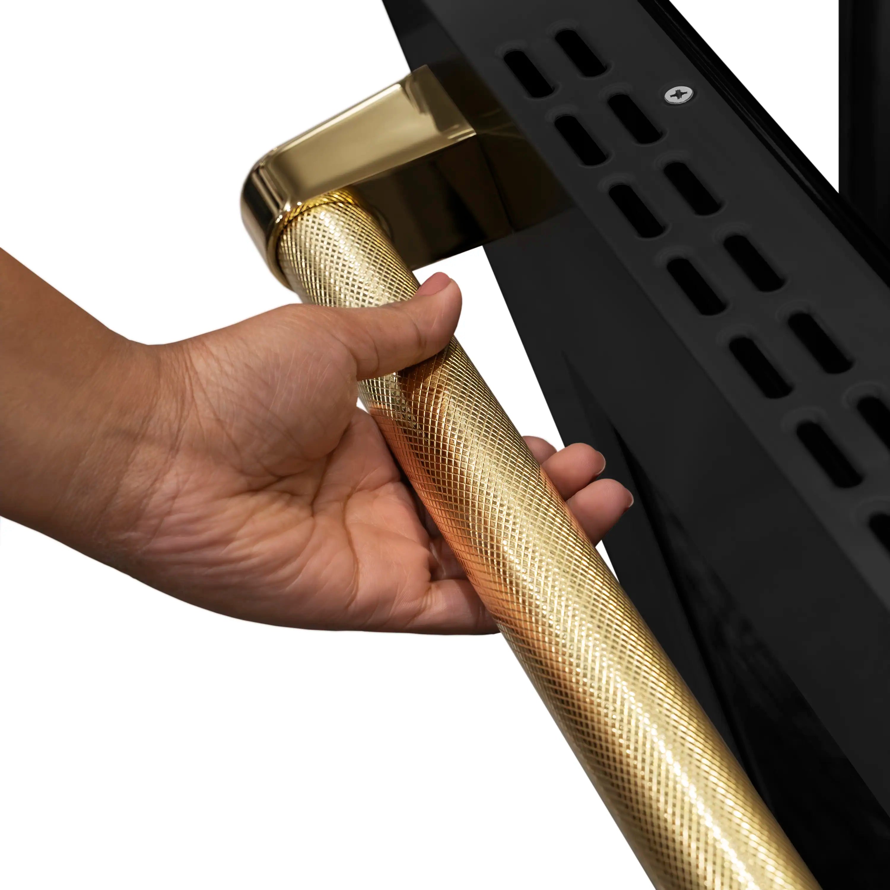 Gold helix oven handle on a black induction range, shown being pulled by a hand
