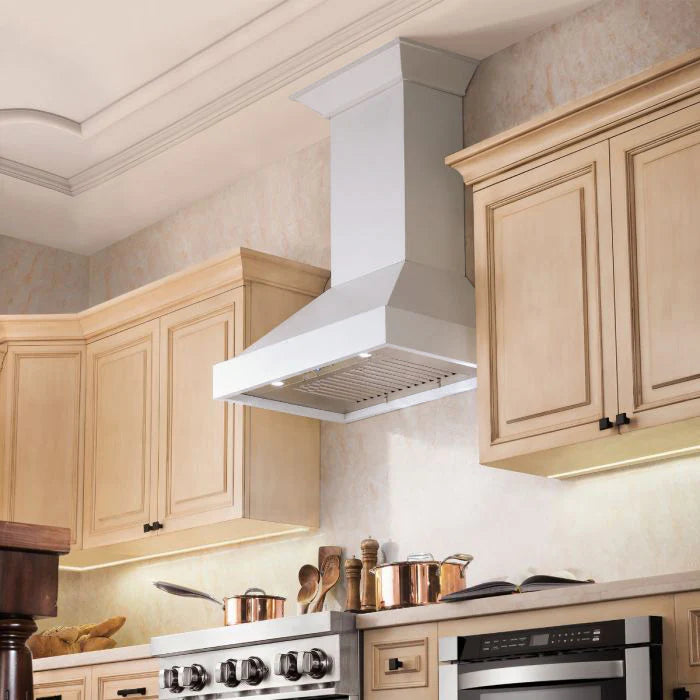 Bright white wall-mount range hood with stainless vent panel above cooktop