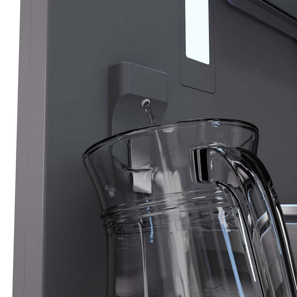 Water dispenser area with clear pitcher beneath the spout on the gray door
