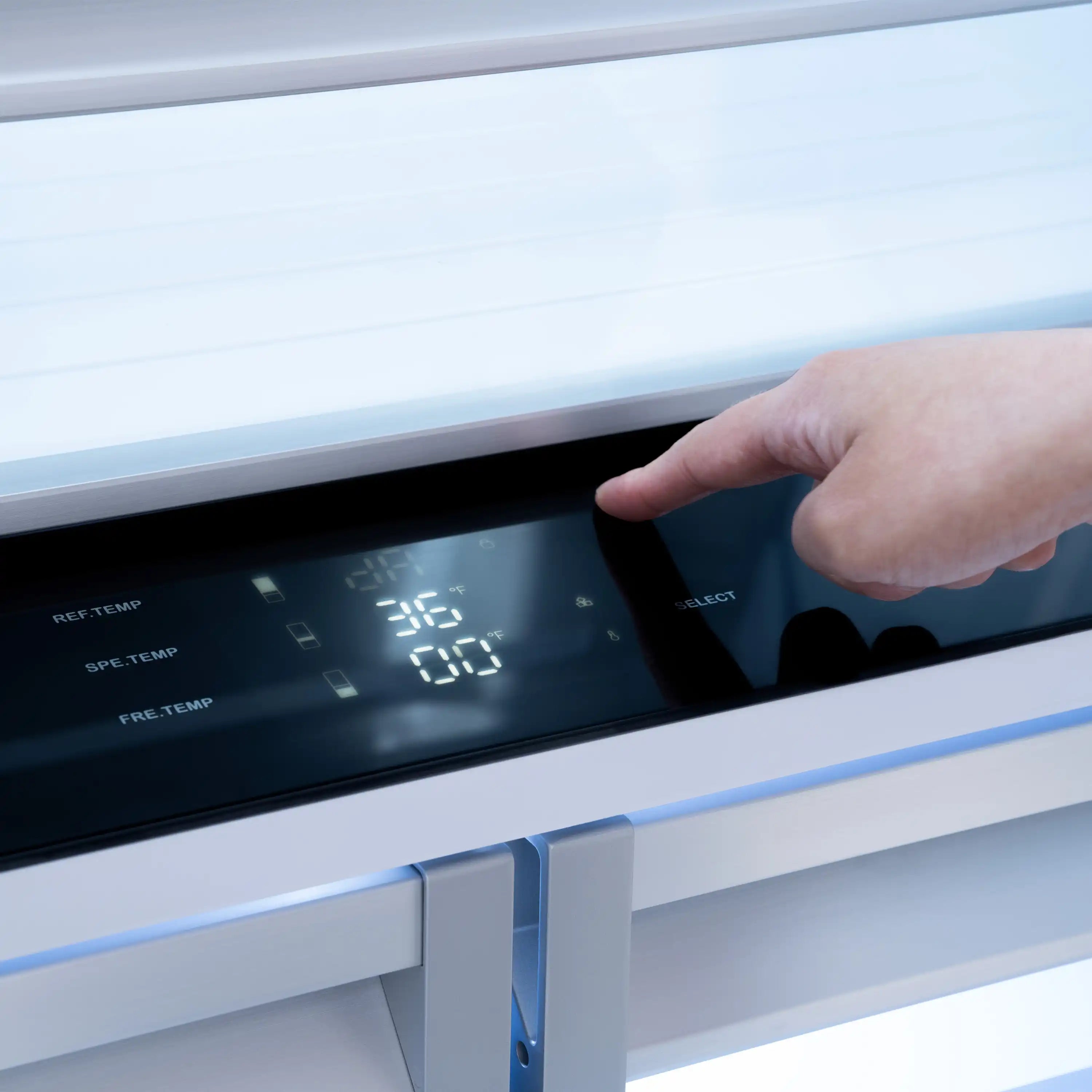 Hand pressing the digital control panel on a white bottom freezer refrigerator