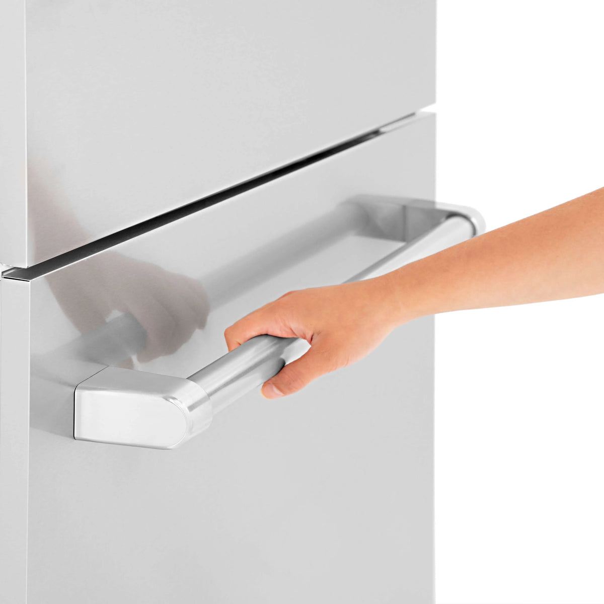 Stainless steel handle on refrigerator door panel being opened by hand