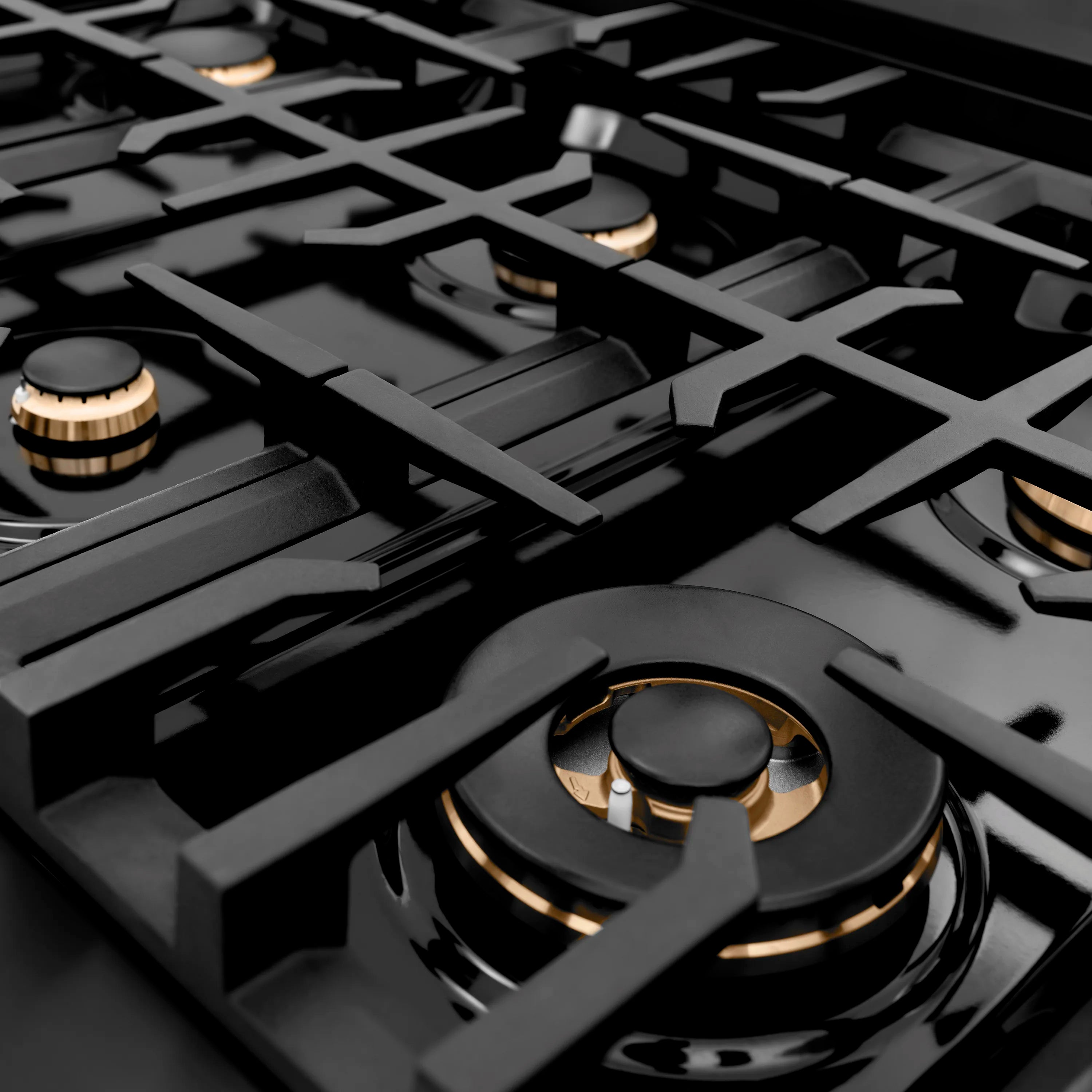 Black gas rangetop with multiple burners and gold-trim burner heads