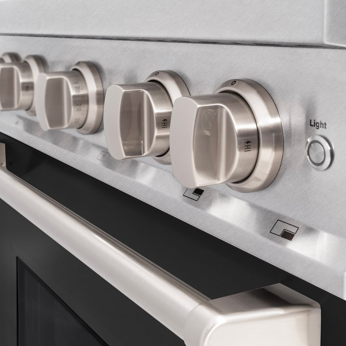Stainless range control panel with four large knobs and indicator icons