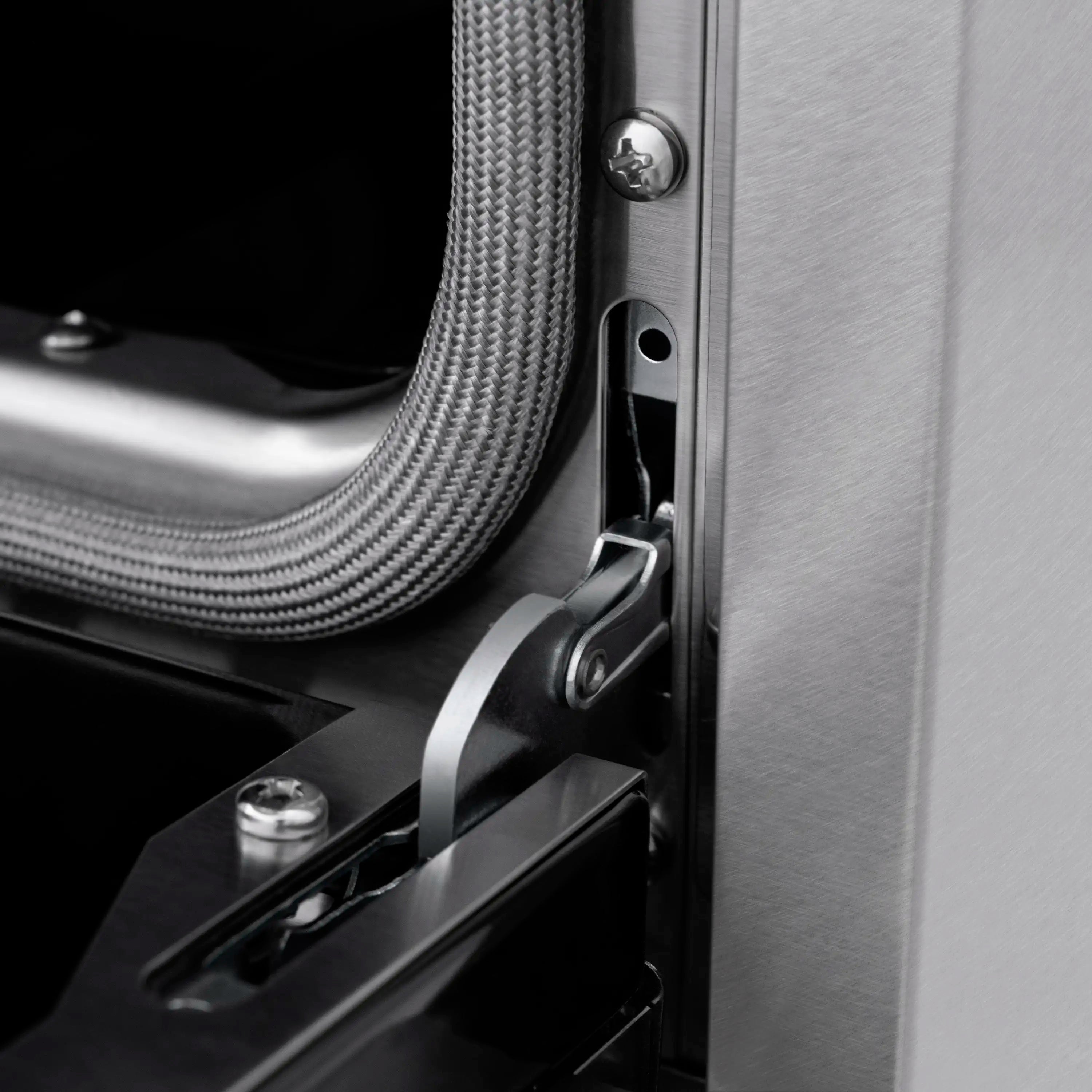 Stainless steel range side with dark control hardware and textured metal gas line connector