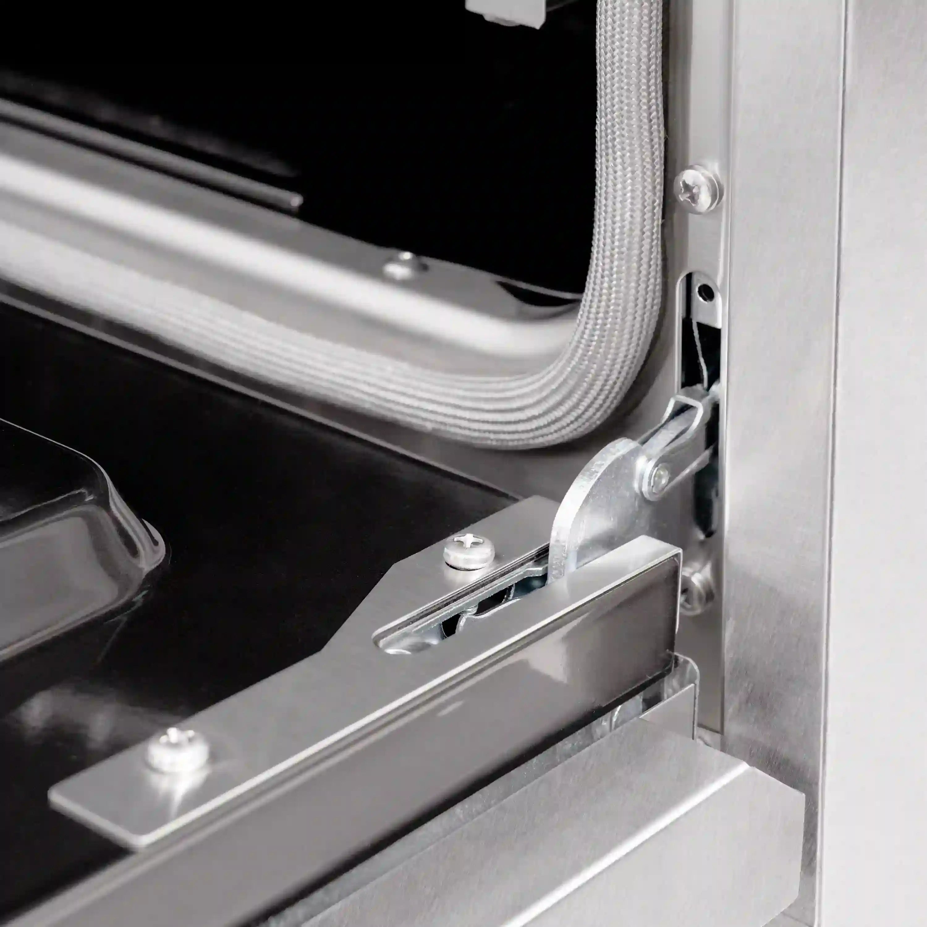 Stainless steel range oven door handle and hinge hardware, with dual fuel oven interior